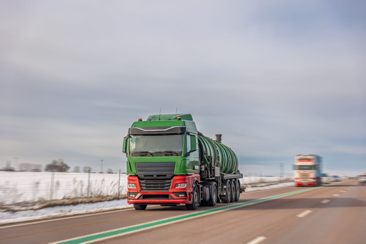 Green tanker truck driving on the highway